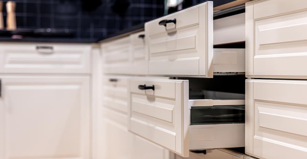 Kitchen cabinetry and storage system example with clean white cabinets.